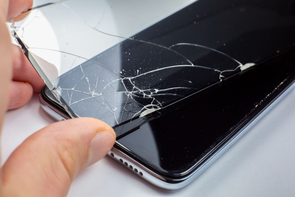 Man replacing the broken tempered glass screen protector for smartphone. Close up.